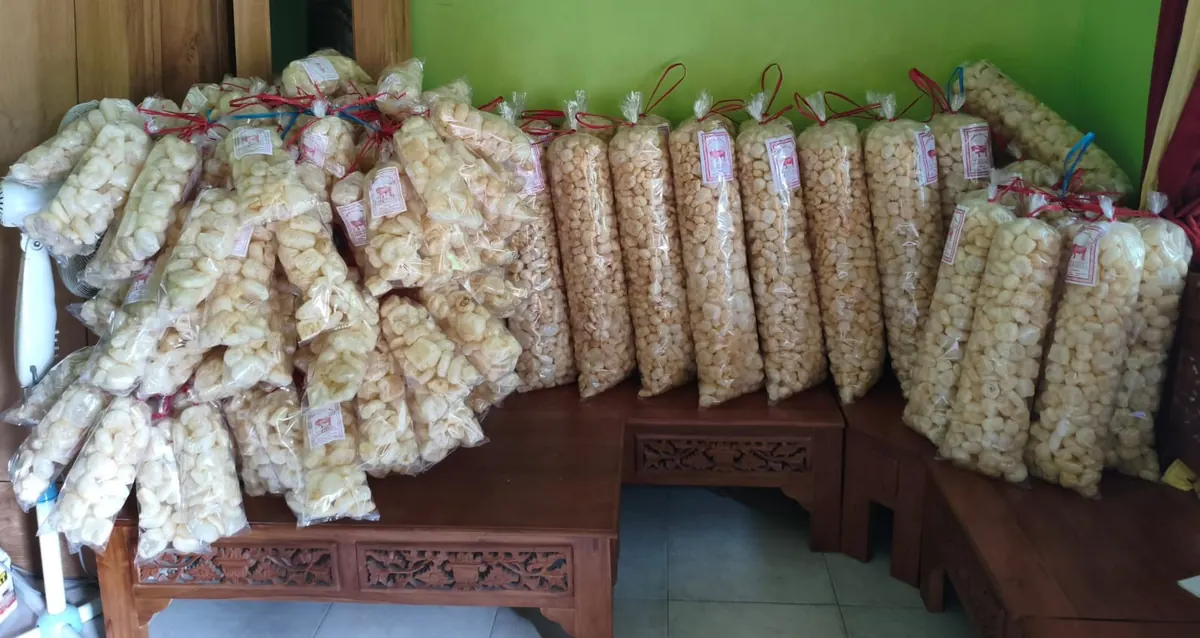 Puluhan kemasan kerupuk kulit sapi tersusun di bangku kayu